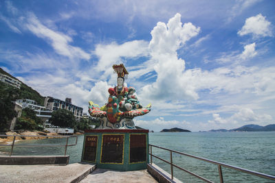 Statue by sea against sky