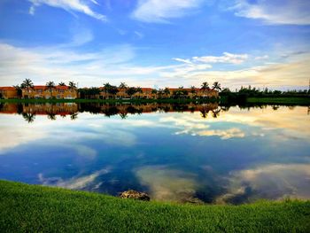 Scenic view of lake by buildings against sky