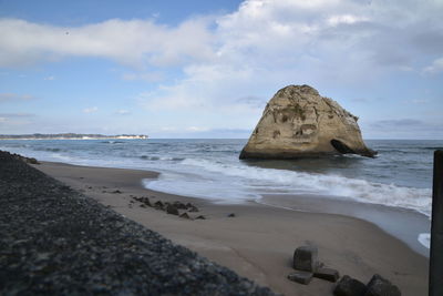 Scenic view of rocks on beach against sky