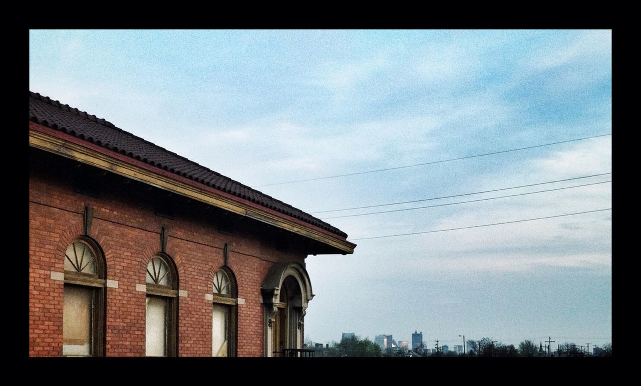 transfer print, architecture, built structure, low angle view, building exterior, sky, auto post production filter, power line, connection, cable, cloud - sky, city, cloud, building, no people, outdoors, day, electricity pylon, arch, cloudy