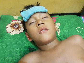High angle portrait of shirtless boy lying