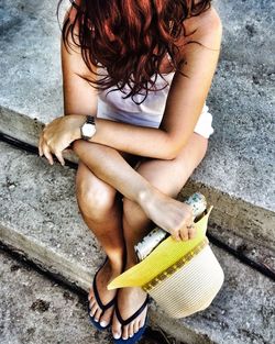 Redhead woman with hat sitting on steps