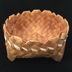 High angle view of wicker basket on paper against black background