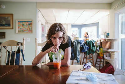 Portrait of friends drinking glass on table