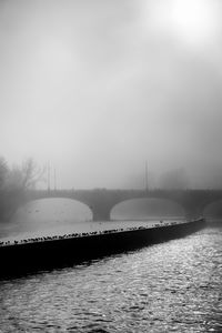 Bridge over river against sky during winter