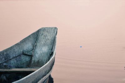 Boat moored on beach against sky during sunset