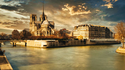 Bridge over river against buildings in city. notre-dame paris france