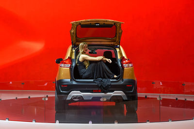Woman sitting in red car