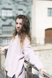 Beautiful teenage girl wearing sweater standing in city