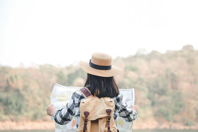 Rear view of woman standing against the sky