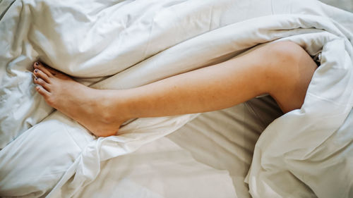 Midsection of woman lying on bed