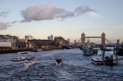 Boats in river against sky in city