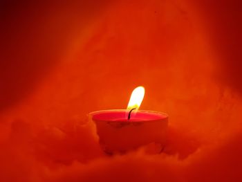 Close-up of lit candle in the dark