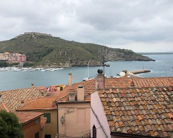 Buildings by sea against sky