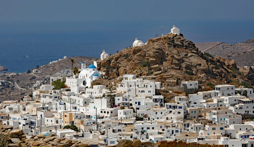 Buildings by sea against sky