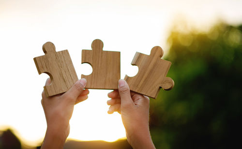 Cropped hand of man holding jigsaw pieces