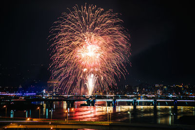 Firework display over river at night