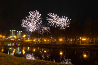Firework display over river at night