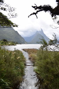 Scenic view of lake by mountains against sky