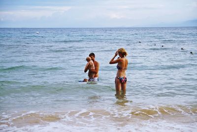 Children on beach against sky