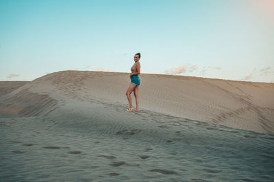 Full length of woman walking on sand at beach