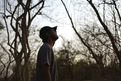 Side view of man against trees at forest