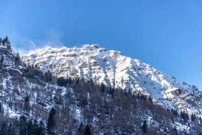 Low angle view of snowcapped mountain against sky