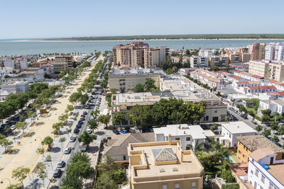 High angle view of townscape by sea against sky
