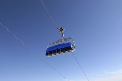 Low angle view of a gondel against clear blue sky