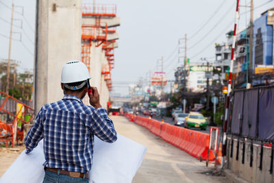 Rear view of man standing on city street