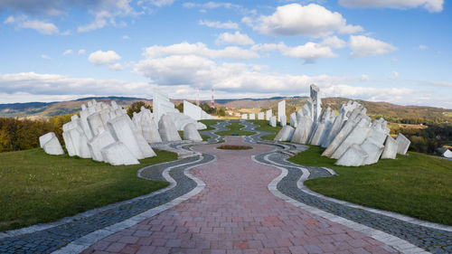 Panoramic view of footpath against cloudy sky