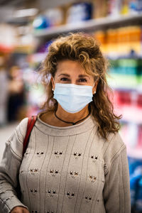 Portrait of woman wearing mask standing in store