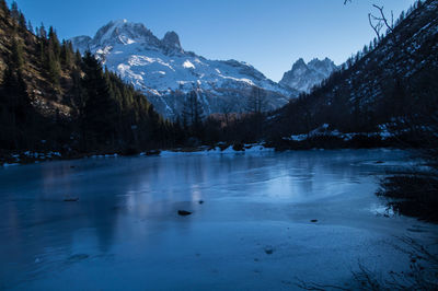 Scenic view of frozen lake by snowcapped mountains