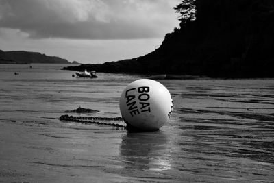 Close-up of ball in sea against sky