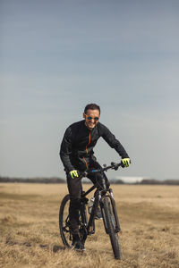 Young man riding a bike on grass field