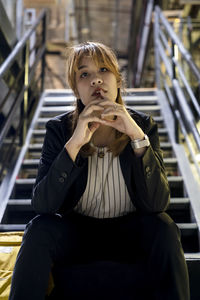 Portrait of young woman sitting on staircase