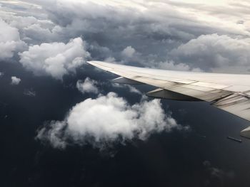 View of airplane wing over clouds