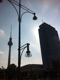 Low angle view of communications tower against cloudy sky