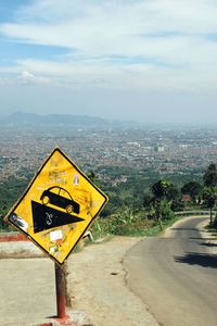 Information sign on road against sky