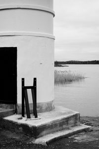 Deck chairs by lake against building