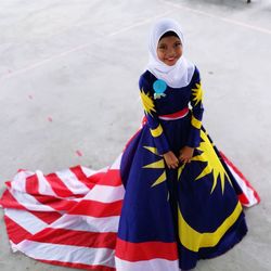 High angle portrait of girl wearing malaysian flag dress and hijab while standing outdoors