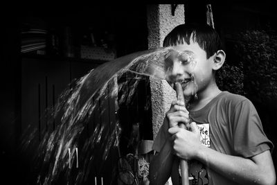 Boy playing with water outdoors