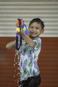 Smiling boy playing with squirt gun