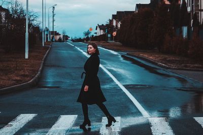 Side view of woman crossing road