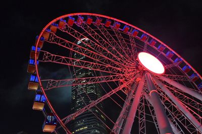 Low angle view of illuminated ferris wheel against sky at night