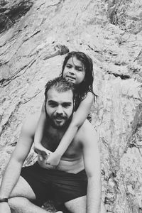 Portrait of father and daughter on rock