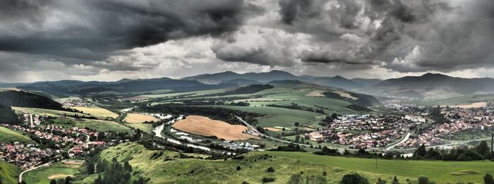 Panoramic view of agricultural field against storm clouds