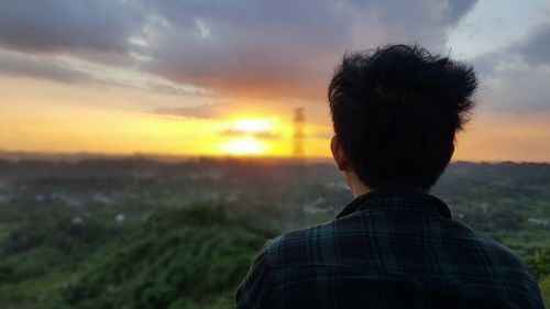 Rear view of man looking at sunset