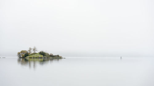 Lone paddle boarder near norfolk island on a misty ullswater 