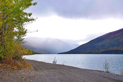 Scenic view of lake by mountains against sky